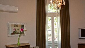 A room with a vintage dresser, a chair, a mirror, and a chandelier. - Palermo Living Unique Rooms (Buenos Aires)