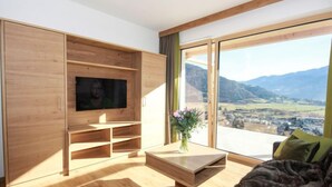 Un salon moderne avec un meuble TV en bois, une table basse et un canapé.