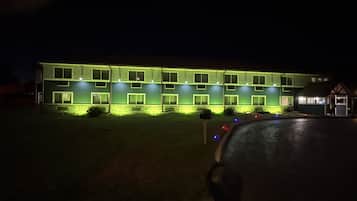 A multi-story building with a flat roof and a series of windows.