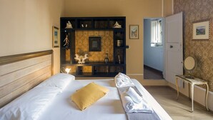 Ein Hotelzimmer mit Bett, Schminktisch mit Spiegel und Blick auf den Flur.