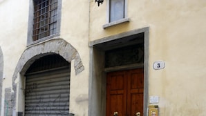Ein Gebäude mit heruntergelassener Metallrollos, einer Holztür mit Messinggriffen und einem kleinen Fenster darüber.