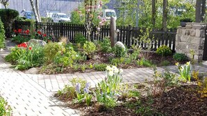A garden with a paved walkway, various plants, and a stone wall. - 85 m² apartment, 3 rooms, kitchen, shower, 15 m² south-west facing balcony (Leipzig)