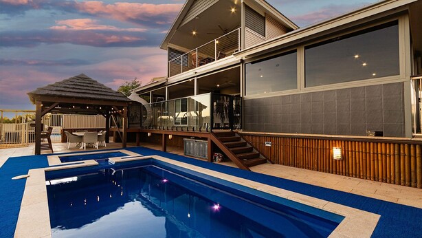 A modern house with a swimming pool, a covered patio, and a large windowed balcony. - 34 Madaffari Drive - Pet friendly Marina Property (Exmouth)