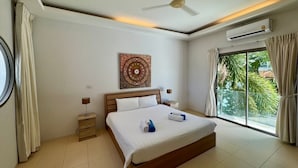 Une chambre moderne avec un grand lit, un ventilateur de plafond, un appareil de climatisation, une table de chevet avec une lampe et une fenêtre avec des rideaux.