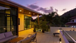 A modern house with a balcony, outdoor seating, and potted plants. - Rooftop Villa - Brand New 3BR Villa (Tambon Rawai)