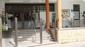 A hotel entrance with a staircase, a sign indicating the hotel name, and a 'P' parking sign. - Hotel El Pino (Teror)