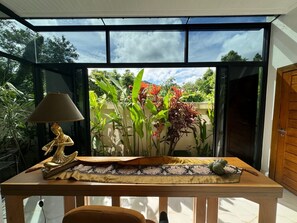 Enjoy a serene atmosphere with a view of lush greenery and a clear sky from this stylish room.