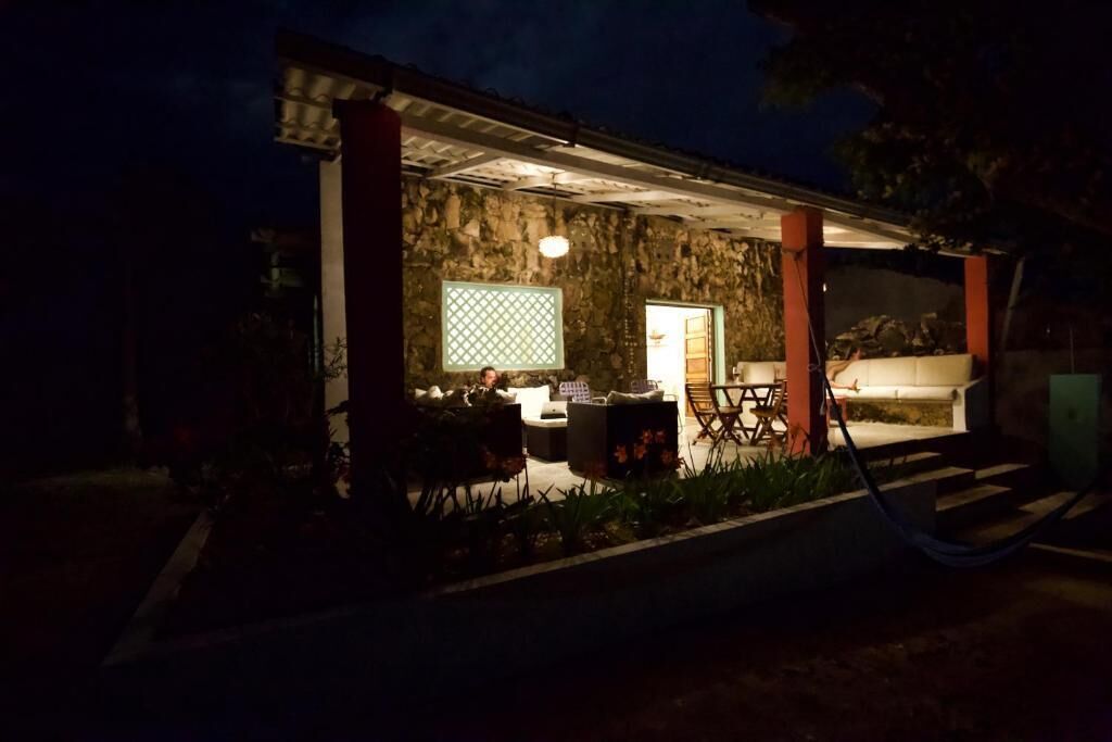 A stone building with a covered patio area, outdoor seating, and a visible entrance.