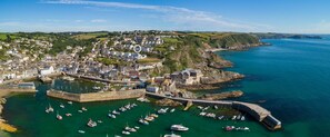 Une ville côtière dotée d’un port historique, de bâtiments en pierre et d’un mélange de constructions résidentielles et commerciales.