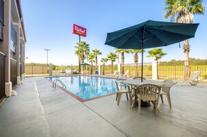 Una piscina al aire libre de temporada, sombrillas, tumbonas