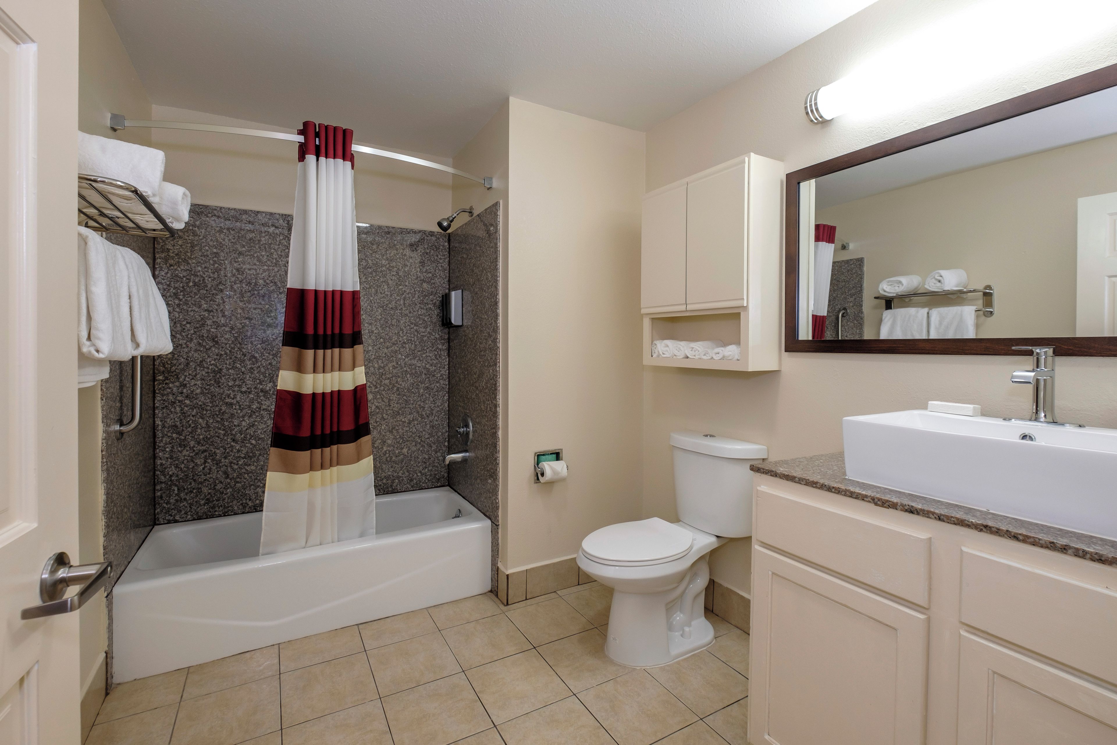 A bathroom with a bathtub, toilet, and a shower curtain.
