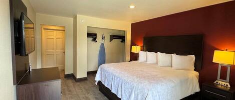 Une chambre d’hôtel avec un grand lit, une télévision, un bureau et une armoire.