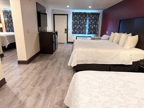 A hotel room with two beds, a desk, a mirror, and a window with curtains. - Red Roof Inn PLUS+ Hammond (Hammond)