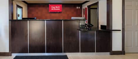 A reception desk with a sign indicating free Wi-Fi in all rooms.