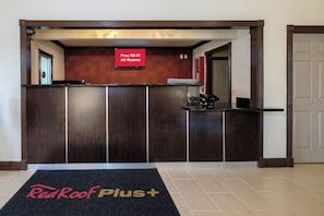 A reception desk with a sign indicating free Wi-Fi in all rooms. - Red Roof Inn PLUS+ Hammond (Hammond)