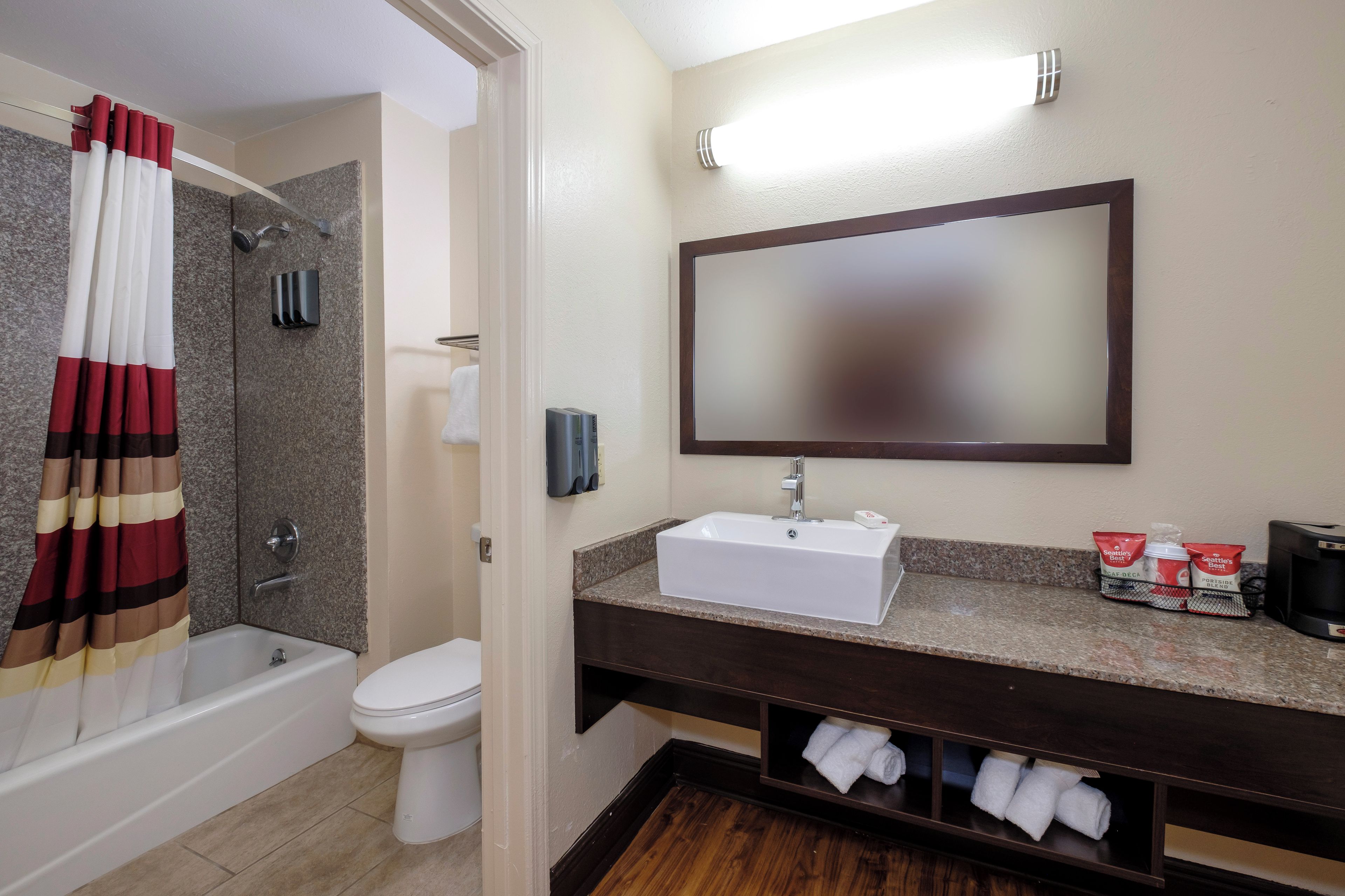 A bathroom with a bathtub, toilet, sink, and a towel rack.