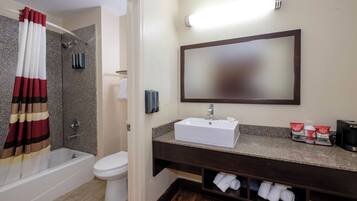A bathroom with a bathtub, toilet, sink, and a towel rack.