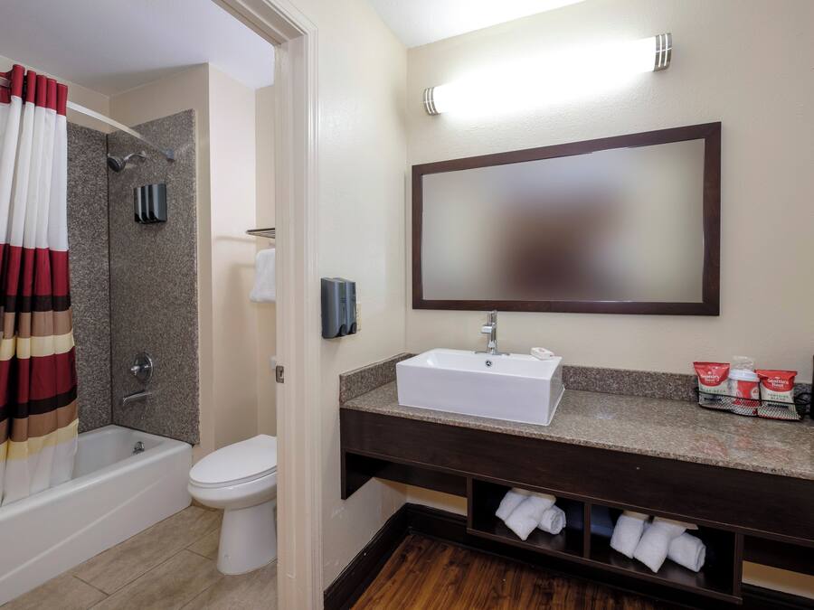 Un baño con bañera, inodoro, lavabo y toallero.