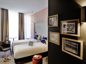 A hotel room with two beds, a desk, a chair, and a small table. There are framed pictures on the wall. - Hôtel Mercure Marseille Canebière Vieux-Port (Marseille)