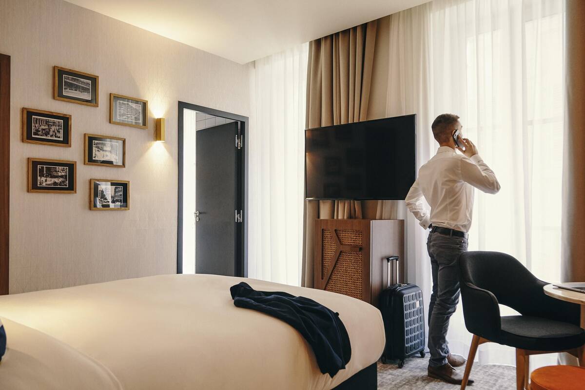 Ein Hotelzimmer mit einem Bett, einem Fernseher, einem Schreibtisch und einem Sessel.
