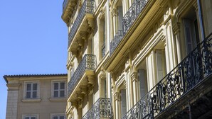 A multi-story building with ornate balconies and shutters. - Hôtel Mercure Marseille Canebière Vieux-Port (Marseille)