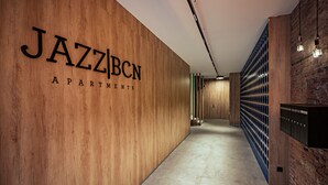 Ein Flur mit einer Holzwand, auf der der Schriftzug 'JAZZBCN APARTMENTS' zu sehen ist.