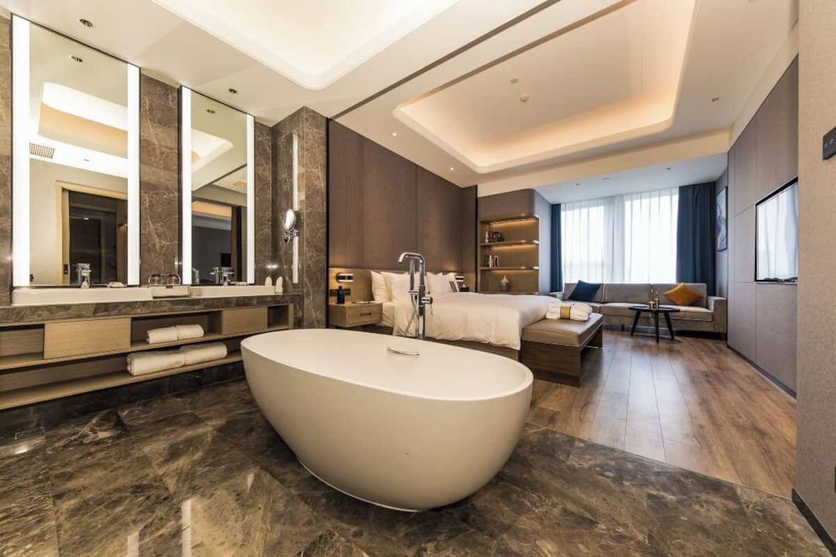 Un baño moderno con una bañera independiente grande, un tocador con espejo y una zona de ducha.