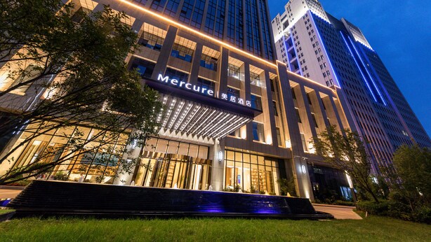 A modern hotel with a prominent entrance, large glass windows, and illuminated signage. - Mercure Xian Hi Tech Zone (Xi'an)
