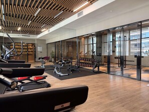 A gym with exercise equipment, a mirrored wall, and a wooden ceiling. - Mercure Xian Hi Tech Zone (Xi'an)