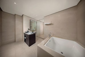 A modern bathroom with a bathtub, a vanity with a mirror, and a glass shower enclosure. - Kaihua International Hotel (Kaihua)