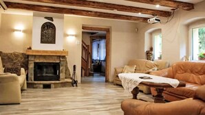 A cozy living room with a fireplace, wooden beams, a sofa, and a table. - Karpacz Kowary by Interhome (Karpacz)