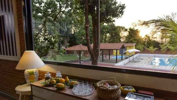 Una encimera de cocina con vista a una piscina, una lámpara y diversos utensilios de cocina.