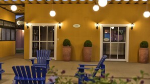 Un espacio al aire libre con sillas azules y plantas en macetas.