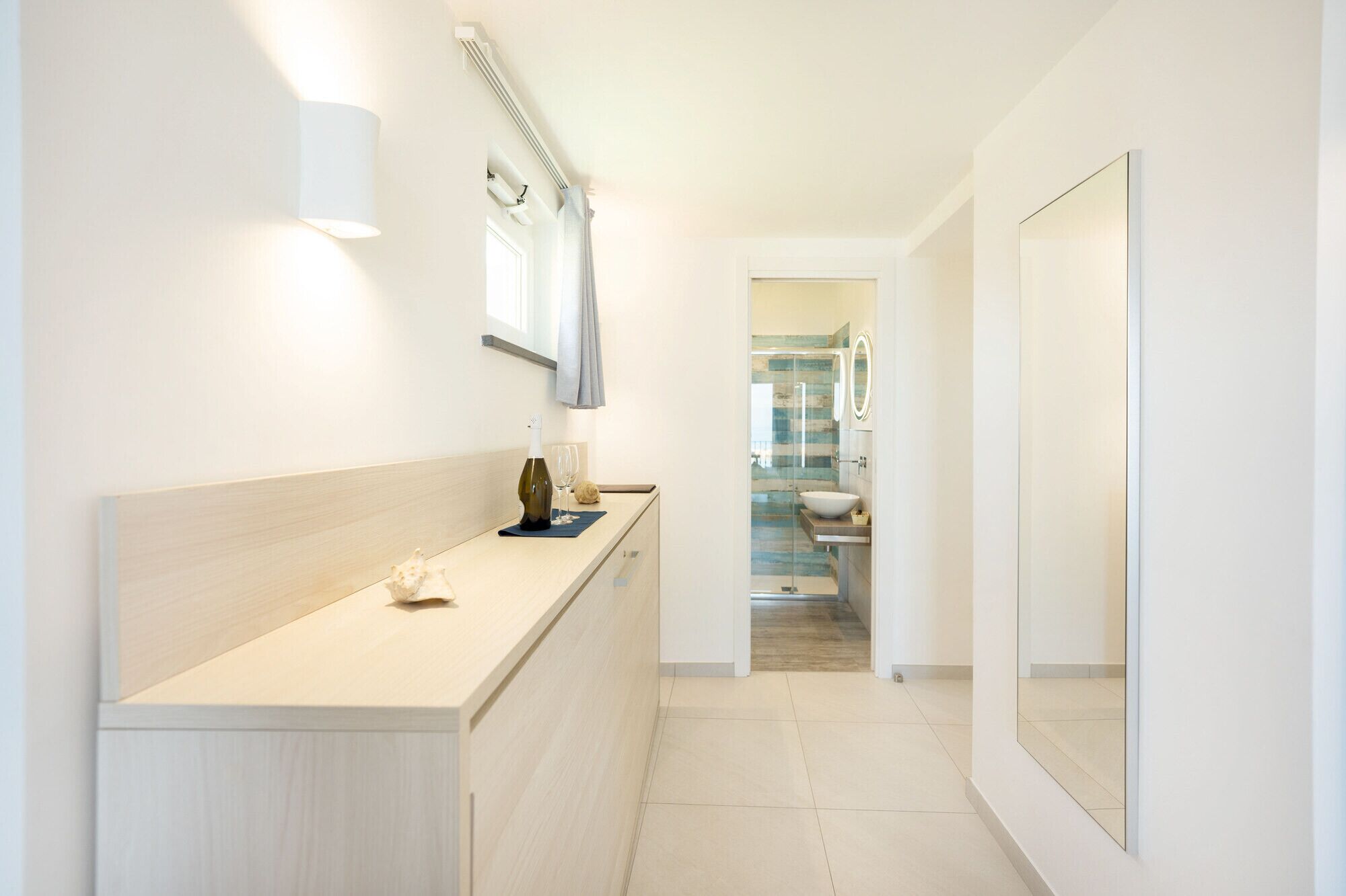 Un baño moderno con cabina de ducha de vidrio, un lavabo blanco y un espejo.
