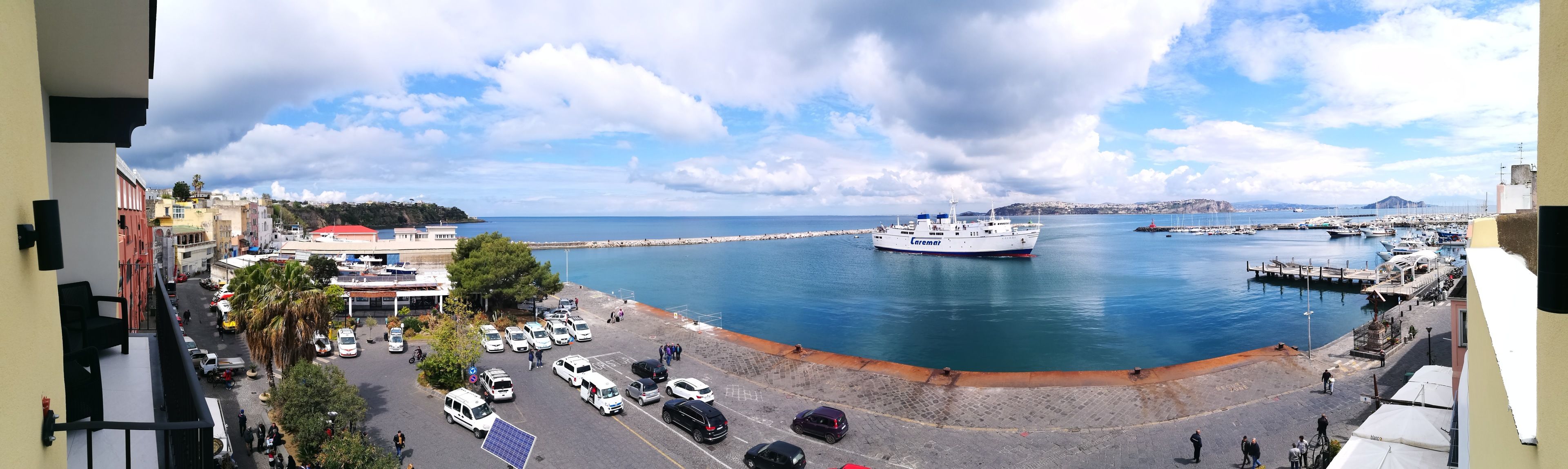 Un puerto deportivo con barcos, un muelle y un edificio con tejado rojo.