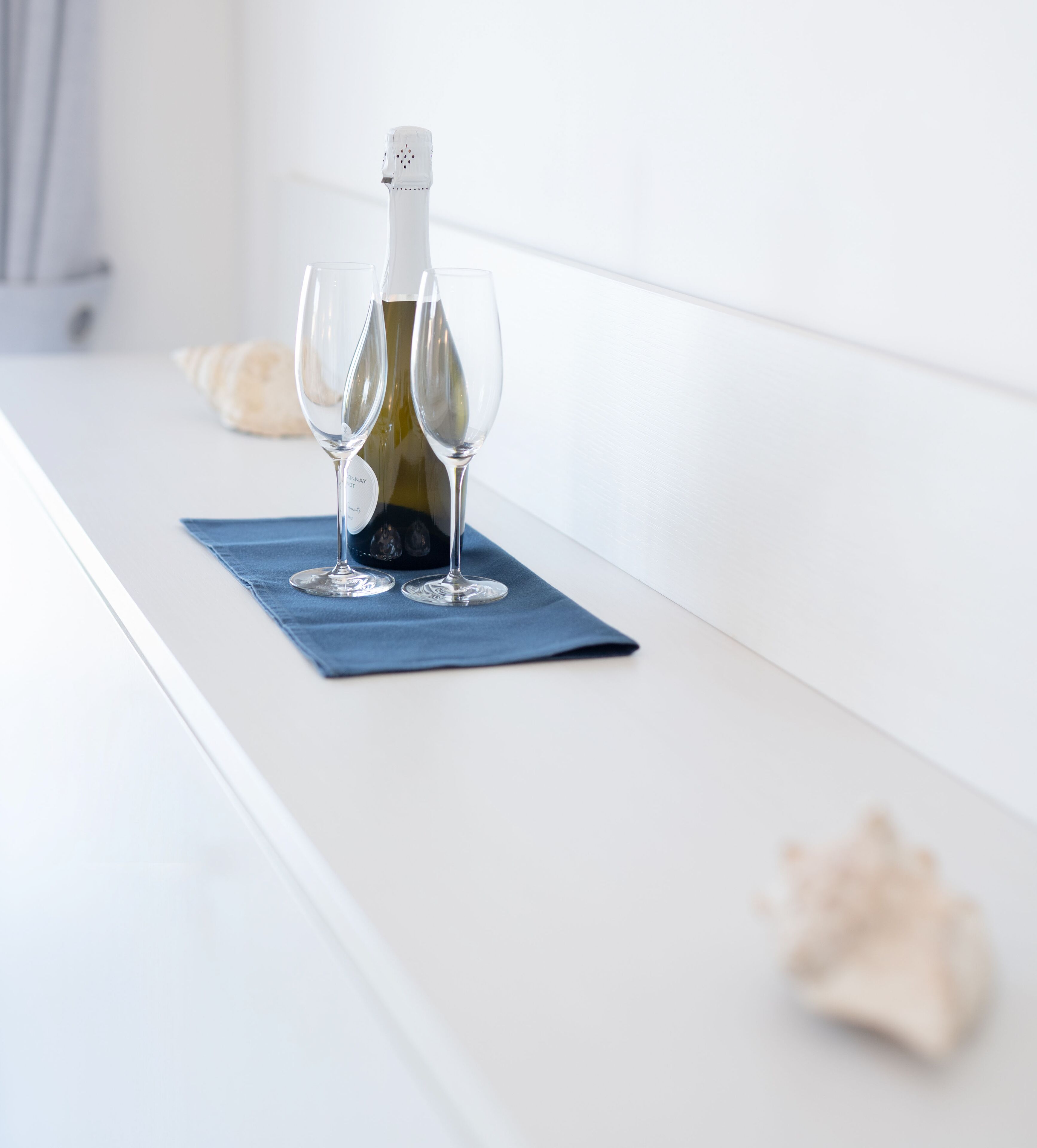 A bottle of wine on a table with two glasses.