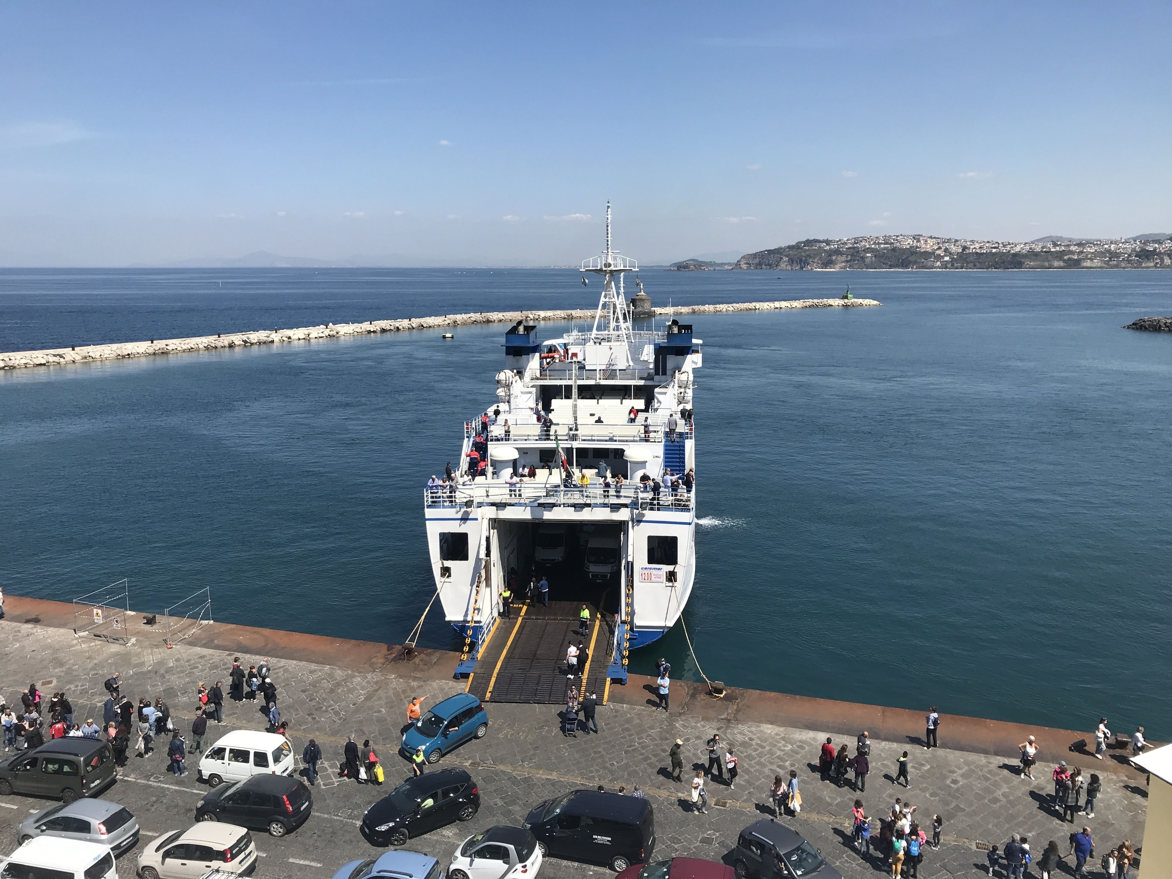 A ferry docked at a pier with passengers disembarking.