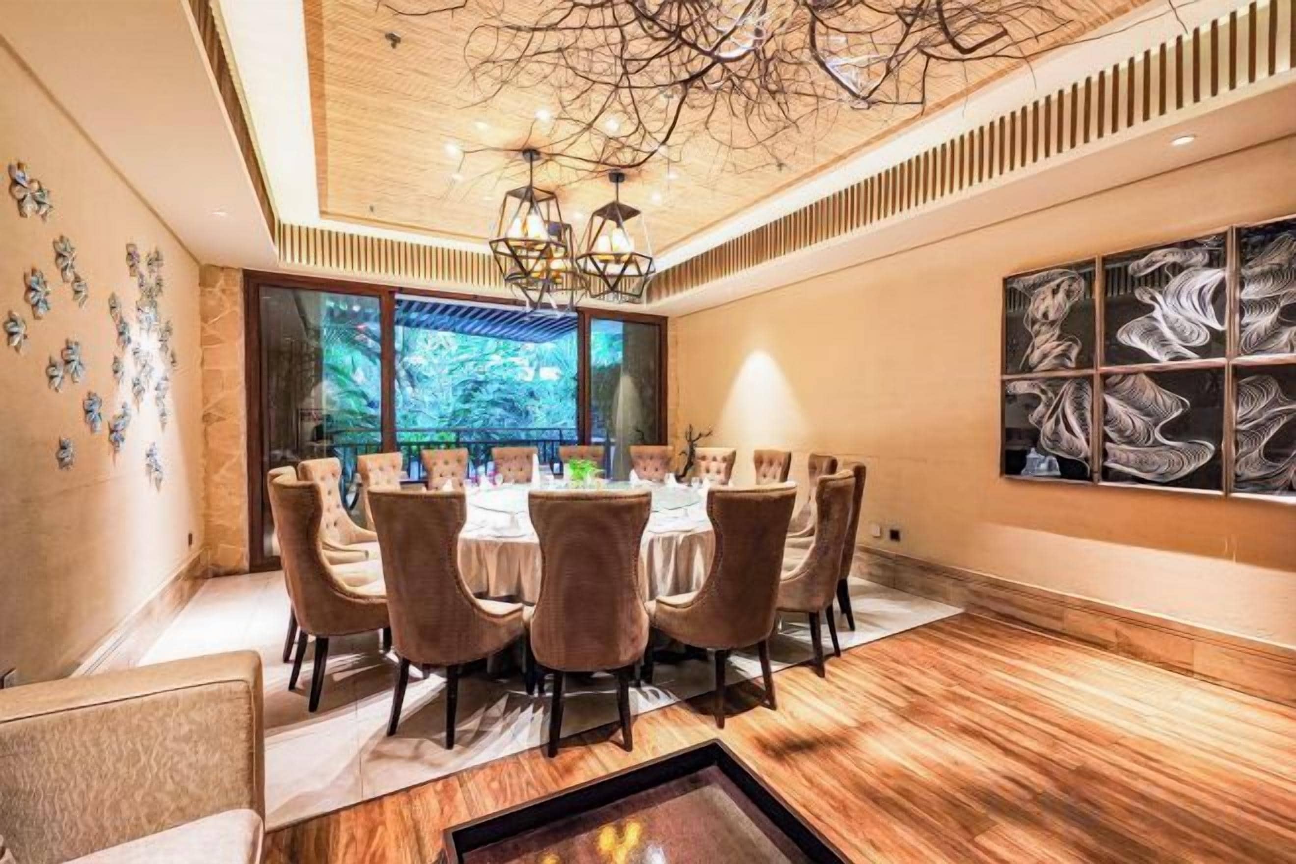 A dining area with a round table, chairs, and a chandelier.