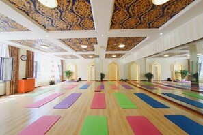 A spacious yoga studio with wooden floors, colorful yoga mats, and a decorative ceiling. - Panjin Ecological Hotel (PANJINU)
