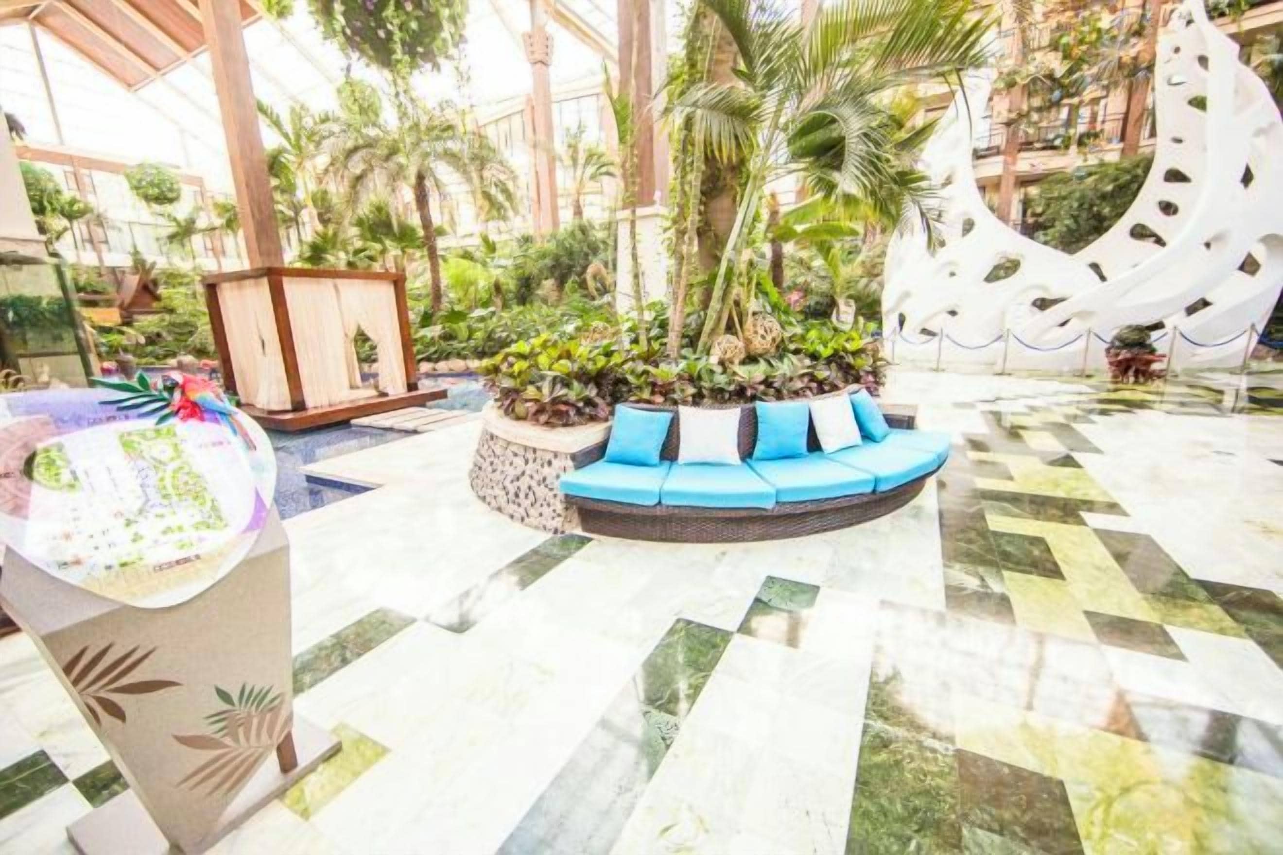 Eine Hotelhalle mit einer Rezeption, einer Sitzecke und einer dekorativen Springbrunnen.