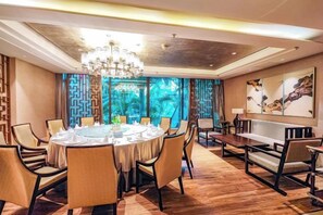 A dining area with a round table, chairs, and a chandelier. - Panjin Ecological Hotel (PANJINU)