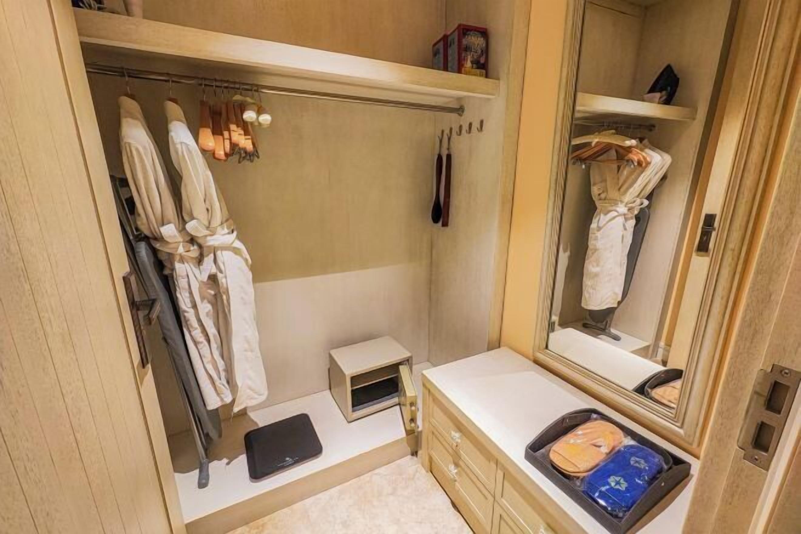 Un baño compacto con vestidor, tocador pequeño y espejo.