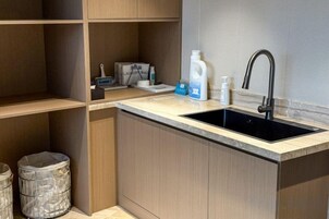 A kitchen with a sink, countertop, and storage cabinets.