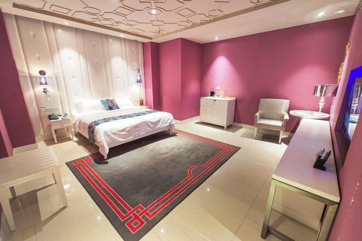 Ein modernes Schlafzimmer mit Bett, Nachttischen, Schreibtisch und Stuhl.