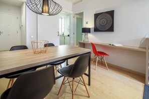 Ein moderner Essbereich mit einem Holztisch, schwarzen und roten Stühlen sowie einer Pendelleuchte.