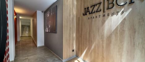Un couloir avec un mur en bois et une enseigne indiquant « JAZZ BCN APARTMENTS ».