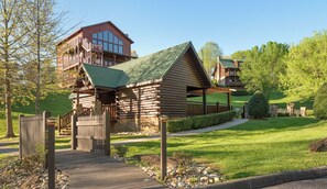 Una cabaña de estilo rústico con una terraza de madera que lleva a una entrada cerrada.