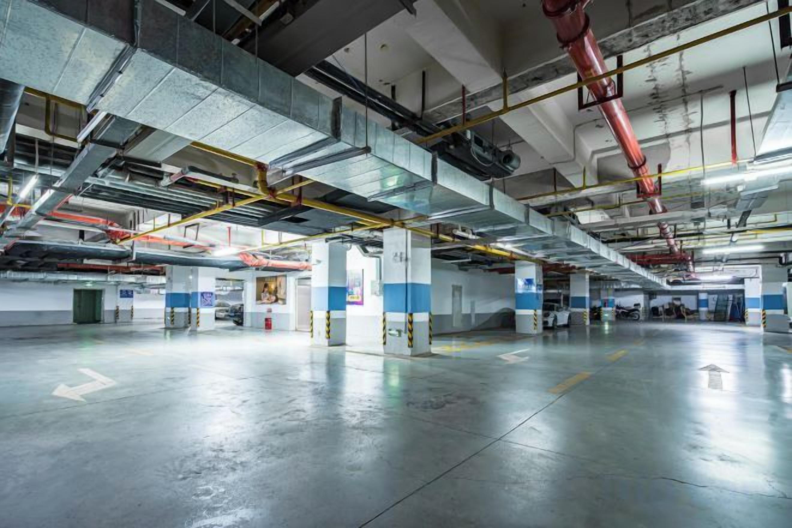 An indoor parking garage with multiple levels, visible structural beams, and a clean, reflective floor.