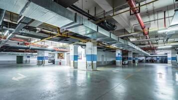 An indoor parking garage with multiple levels, visible structural beams, and a clean, reflective floor.