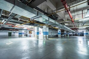 An indoor parking garage with multiple levels, visible structural beams, and a clean, reflective floor. - Huaxin Hotel (XIANNING)